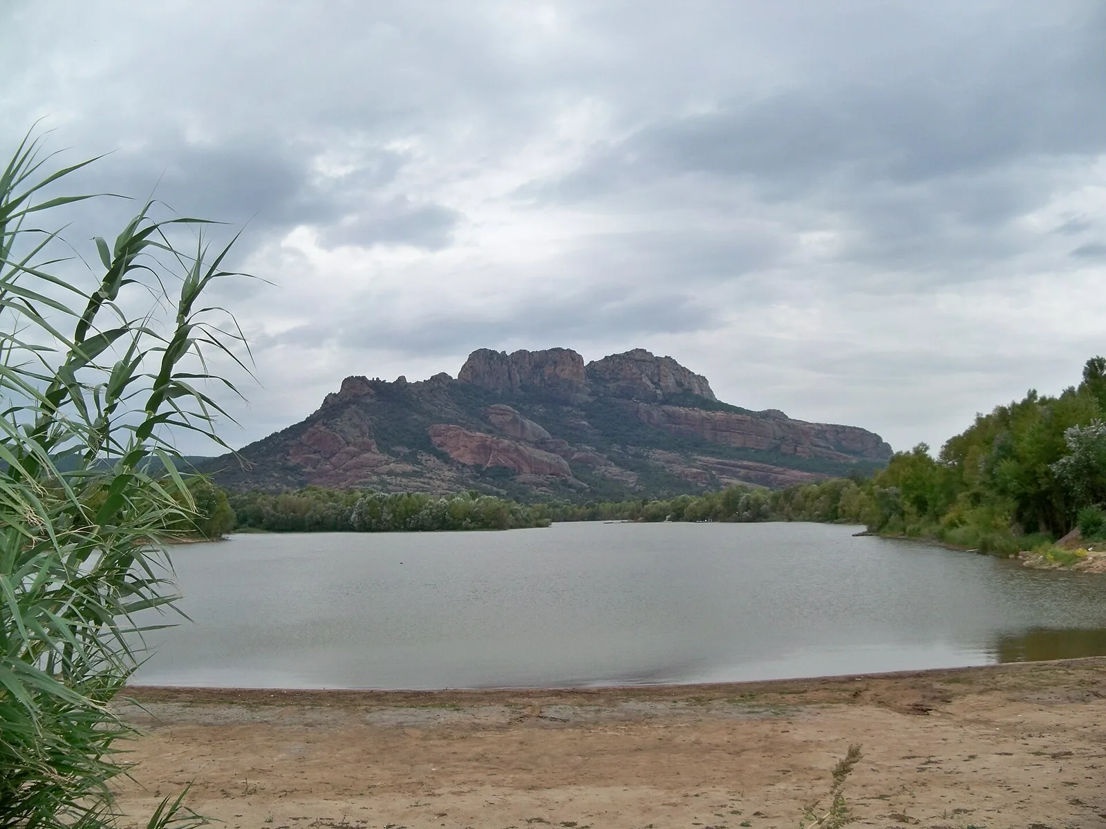 Le rocher de Roquebrune, massif de grès rouge, vu depuis le lac de l'Aréna